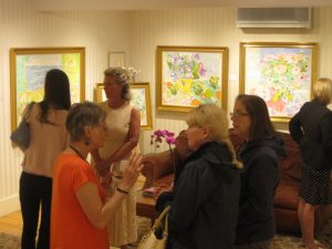 Lillia Frantin (in orange) speaking with exhibition attendees